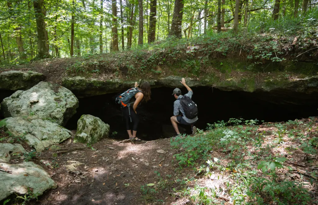 hikers looking into alamo cave, one of many caves along the Chipola