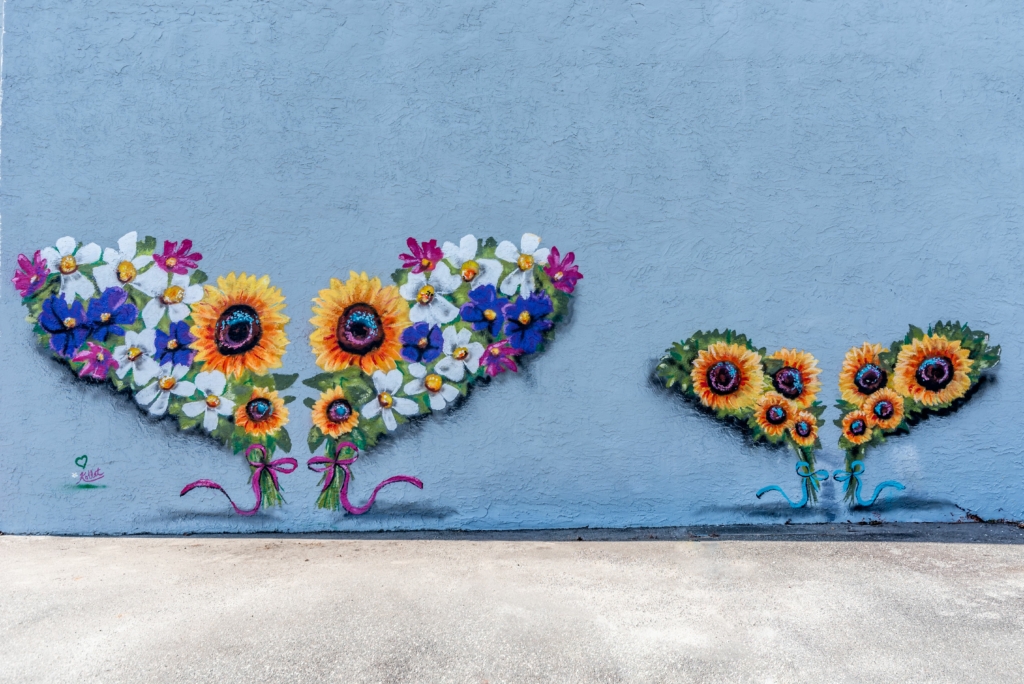 large floral wings with ribbons painted on a building